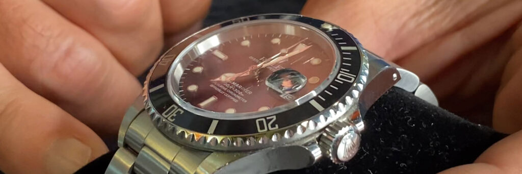closeup of a stainless steel Rolex showing Rolex movement history