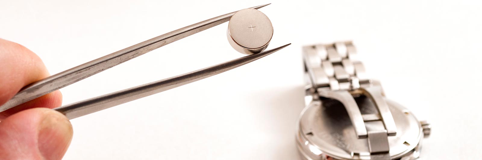 watch expert removing a leaking battery from a luxury watch