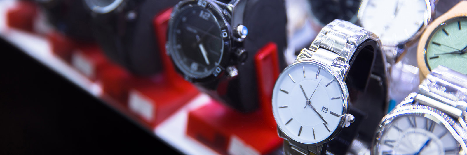 Assorted counterfeit and imitation watches displayed in a row inside a shop