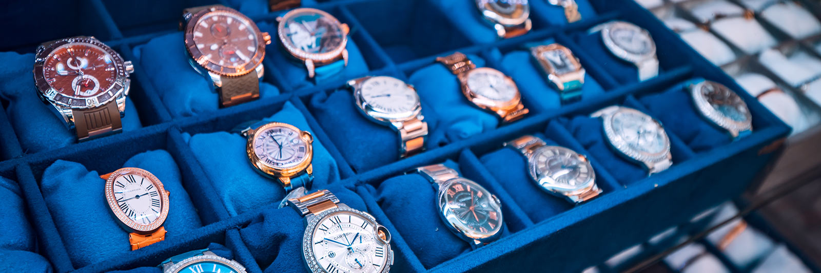 a collection of fake luxury watches on a table being sold