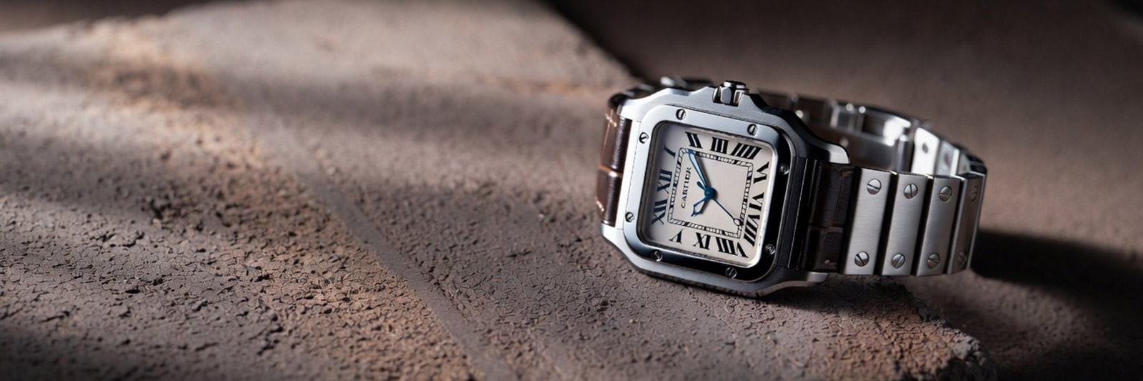 cartier santos watch on concrete surface